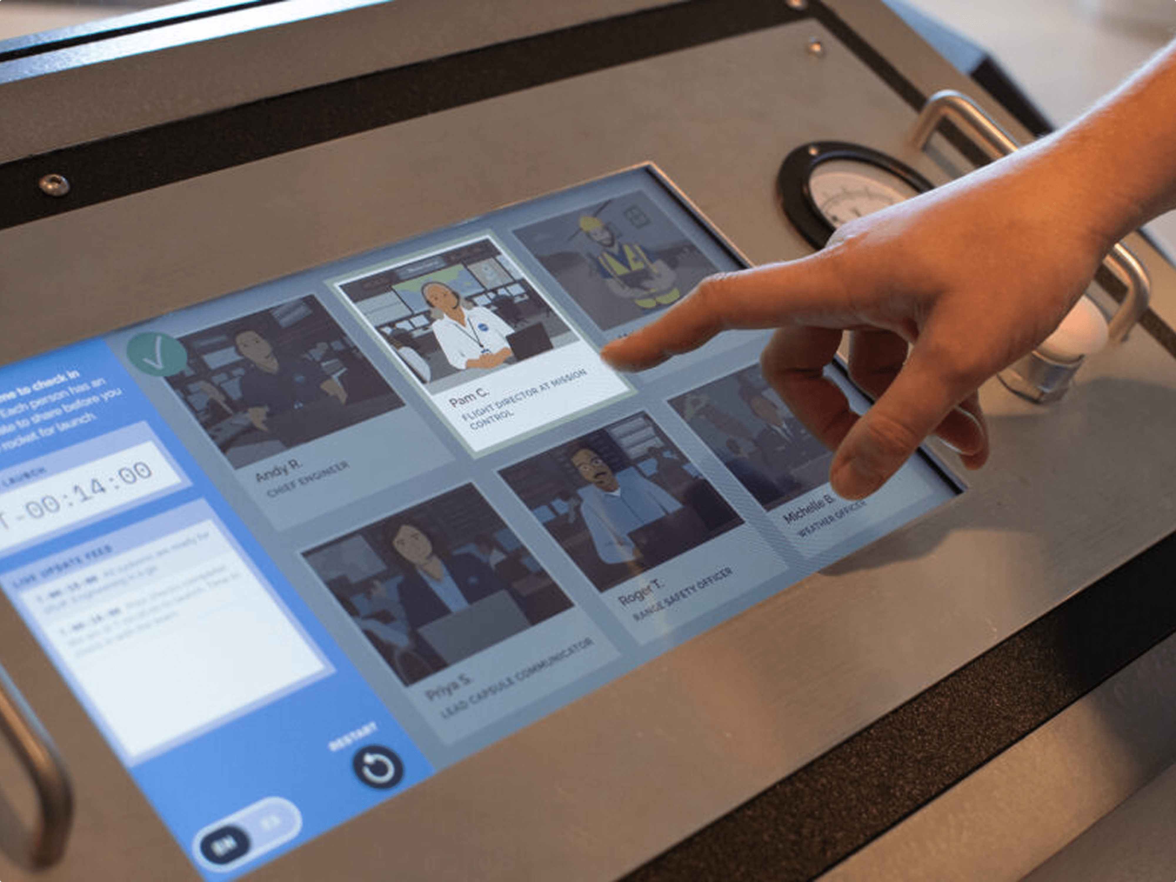Panel-mount touchscreen in metal exhibit console with gauge and button.